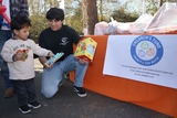 Children's Fund employee gives toy to child.